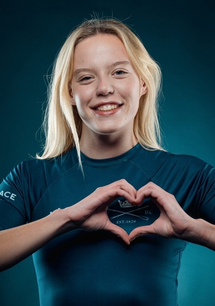 OUBC athlete in dark blue top making heart sign