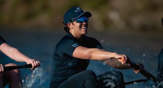 Woman in dark blue Oxford kit racing